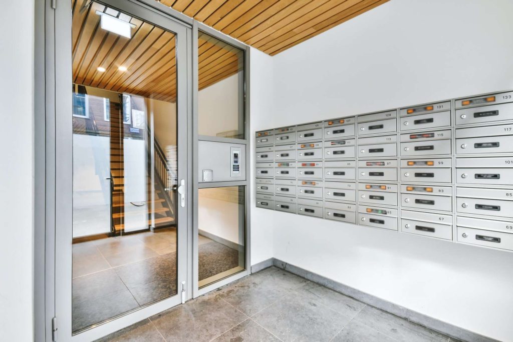 Mail boxes near glass door of apartment building